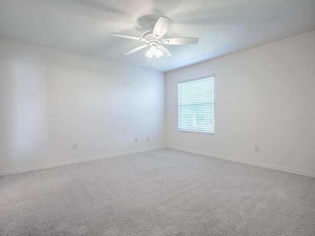 empty room with light carpet, ceiling fan, and a textured ceiling