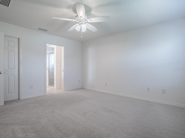 unfurnished room featuring light carpet, ceiling fan, and a textured ceiling