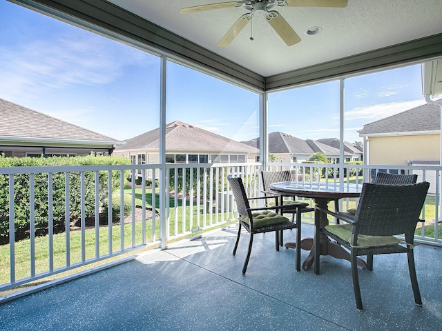 unfurnished sunroom with ceiling fan