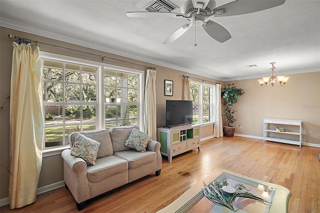 living room with plenty of natural light, crown molding, ceiling fan with notable chandelier, and light hardwood / wood-style flooring