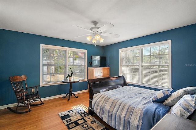 bedroom with multiple windows, ceiling fan, and hardwood / wood-style floors