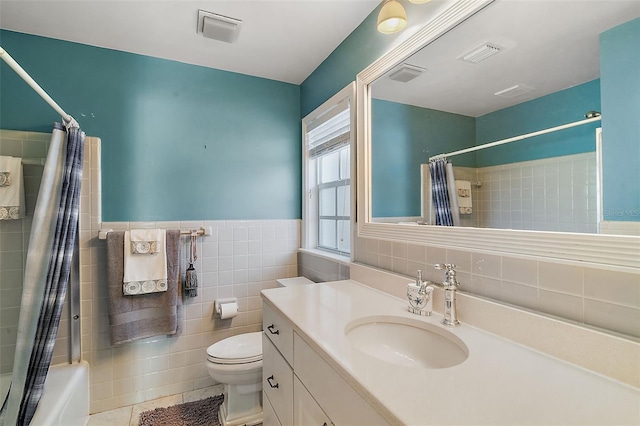 full bathroom featuring vanity, tile patterned floors, toilet, shower / bathtub combination with curtain, and tile walls