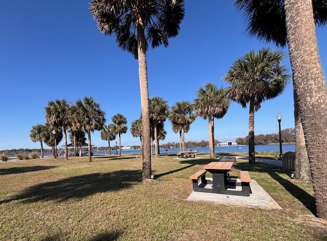 view of home's community featuring a lawn and a water view