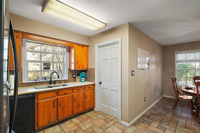 kitchen with tasteful backsplash, stainless steel fridge, sink, and black dishwasher