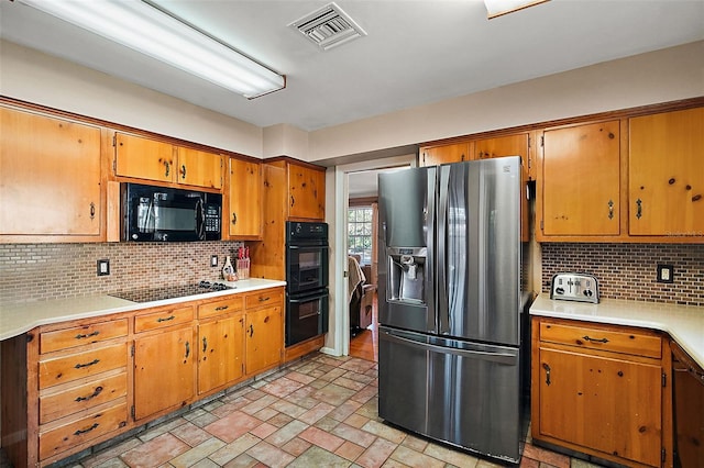 kitchen featuring black appliances and backsplash