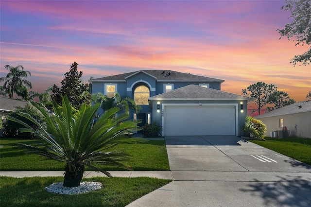 1087 Welch Hill Cir, Apopka, FL 32712 - traditional-style home featuring an attached garage, concrete driveway, stucco siding, a lawn, and central AC unit