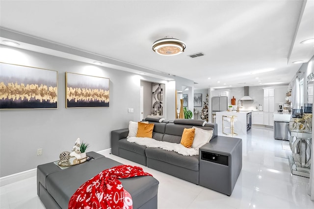 living room featuring sink and light tile patterned floors