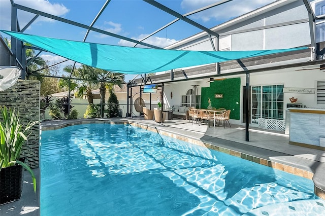 view of swimming pool featuring ceiling fan, a patio, and glass enclosure