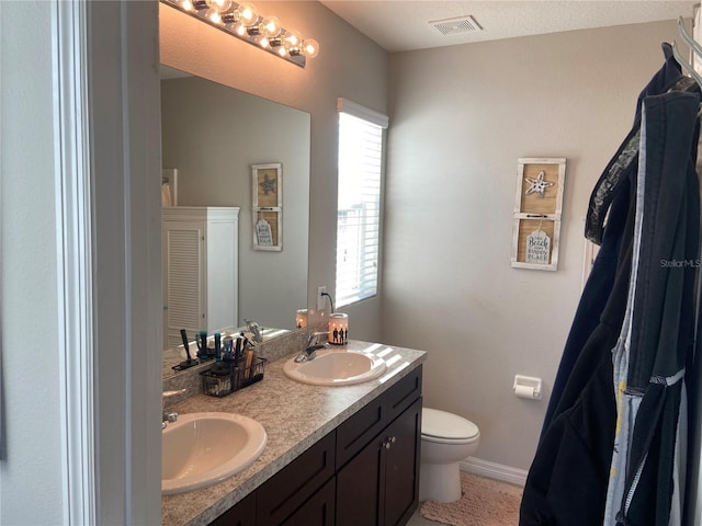 bathroom featuring vanity, a textured ceiling, and toilet