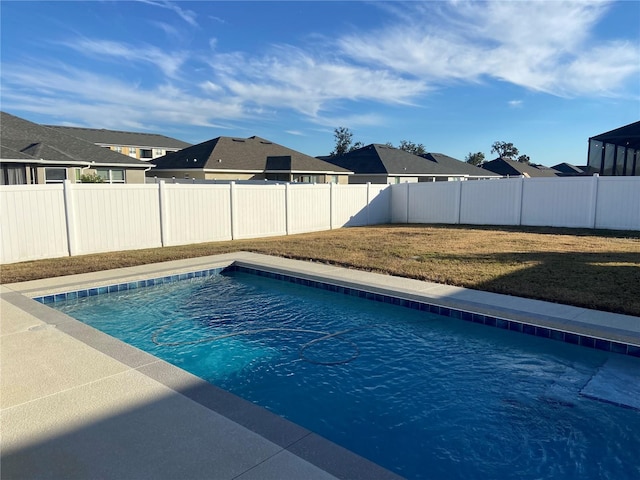 view of swimming pool with a yard