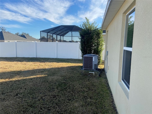 view of yard featuring glass enclosure and central air condition unit