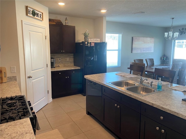 kitchen featuring pendant lighting, black appliances, sink, light tile patterned floors, and a chandelier