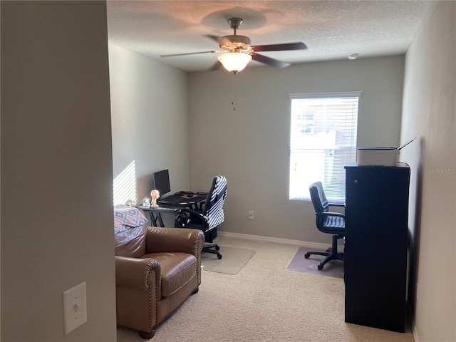 carpeted office featuring ceiling fan and a textured ceiling