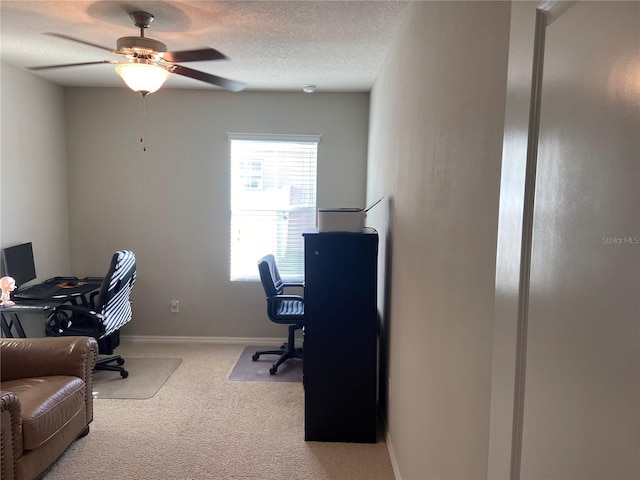 office with a textured ceiling, light colored carpet, and ceiling fan