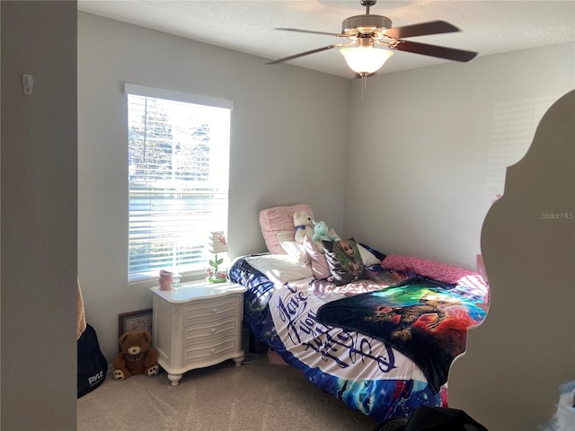 bedroom with carpet, a textured ceiling, multiple windows, and ceiling fan