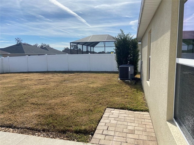 view of yard featuring a lanai and central AC unit