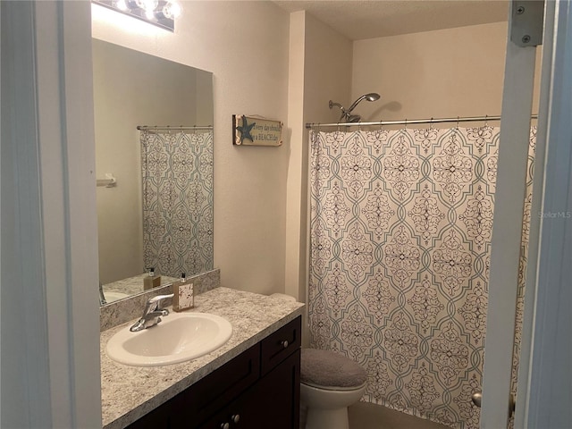 bathroom featuring vanity, toilet, and a textured ceiling