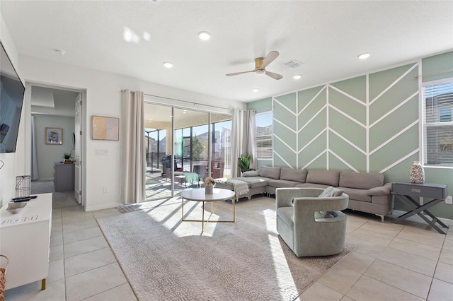 living room featuring ceiling fan, light tile patterned floors, and a textured ceiling