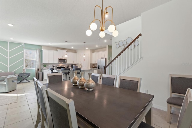 tiled dining area with a textured ceiling and a notable chandelier