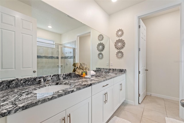 bathroom with tile patterned flooring, vanity, and a shower with door