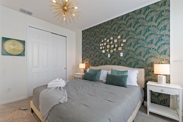 carpeted bedroom featuring an inviting chandelier and a closet