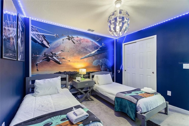 bedroom with a closet, carpet floors, and a chandelier