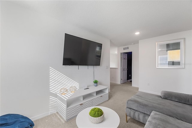 living room featuring light colored carpet and a textured ceiling