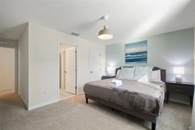 bedroom featuring a textured ceiling and light carpet