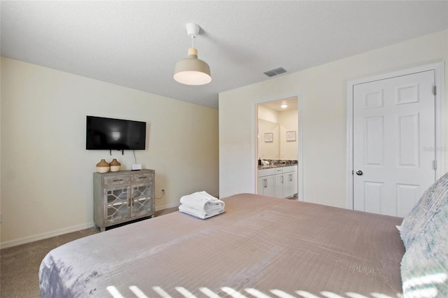 carpeted bedroom featuring ensuite bath