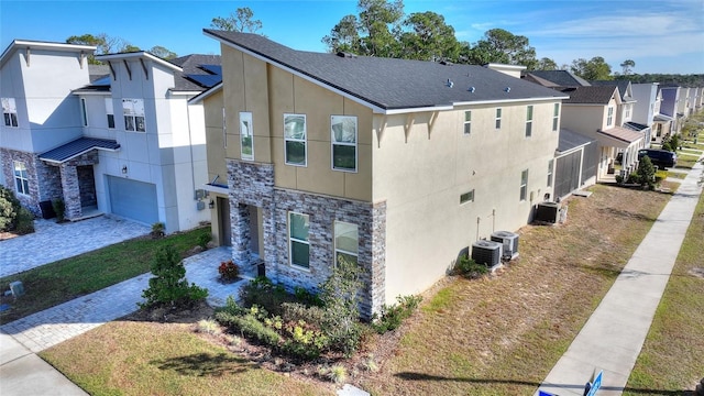 view of side of property featuring a garage and central air condition unit