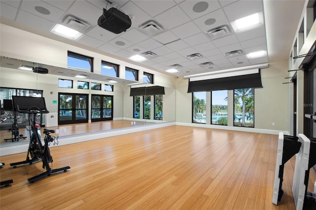 exercise room featuring a paneled ceiling and hardwood / wood-style flooring