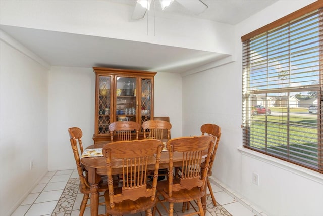 dining space with ceiling fan and light tile patterned flooring