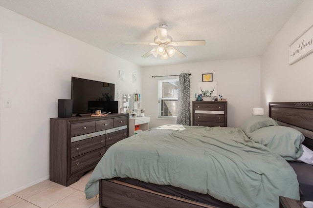 bedroom featuring ceiling fan, light tile patterned flooring, and a textured ceiling