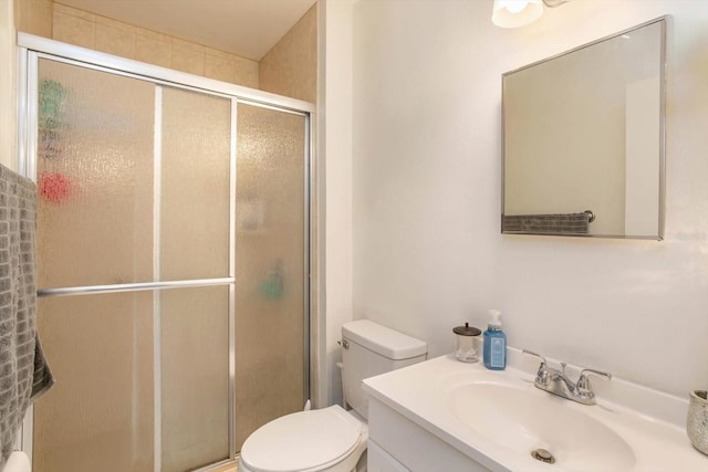 bathroom featuring vanity, an enclosed shower, and toilet