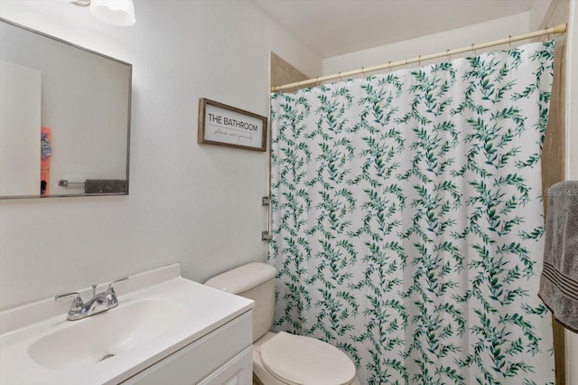 bathroom featuring a shower with shower curtain, vanity, and toilet