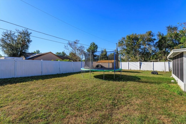 view of yard featuring a trampoline and a sunroom