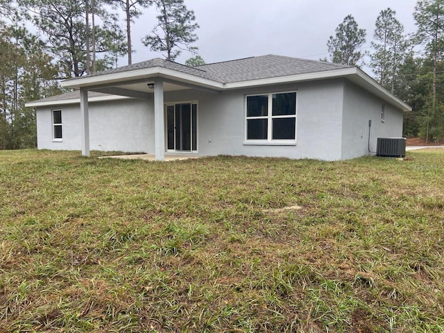 rear view of house featuring a lawn and cooling unit