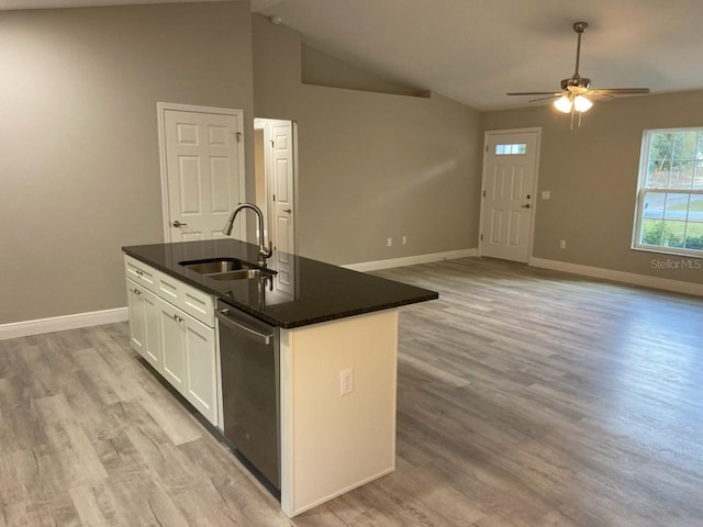 kitchen featuring sink, stainless steel dishwasher, lofted ceiling, a center island with sink, and white cabinets