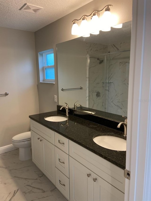 bathroom with vanity, a shower with shower door, a textured ceiling, and toilet