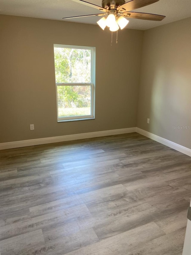 empty room with light wood-type flooring and ceiling fan