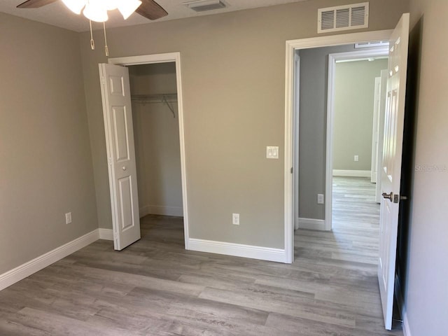 unfurnished bedroom featuring ceiling fan, a closet, and light hardwood / wood-style flooring