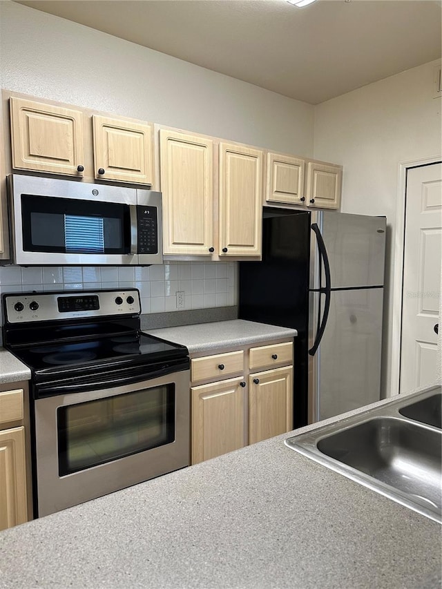 kitchen with decorative backsplash, sink, stainless steel appliances, and light brown cabinets