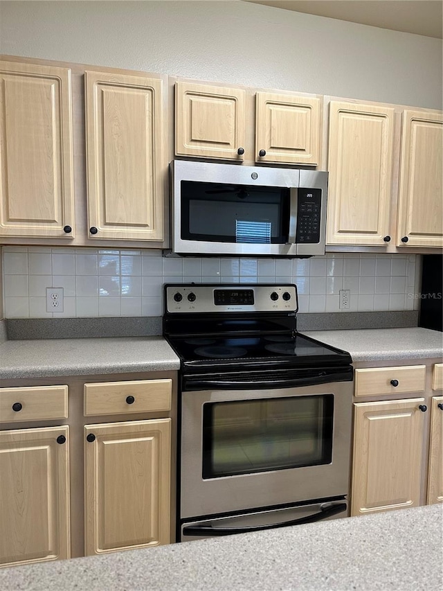 420 Summit Ridge Pl Unit 214, Longwood, FL 32779 - kitchen featuring appliances with stainless steel finishes, light brown cabinets, and decorative backsplash