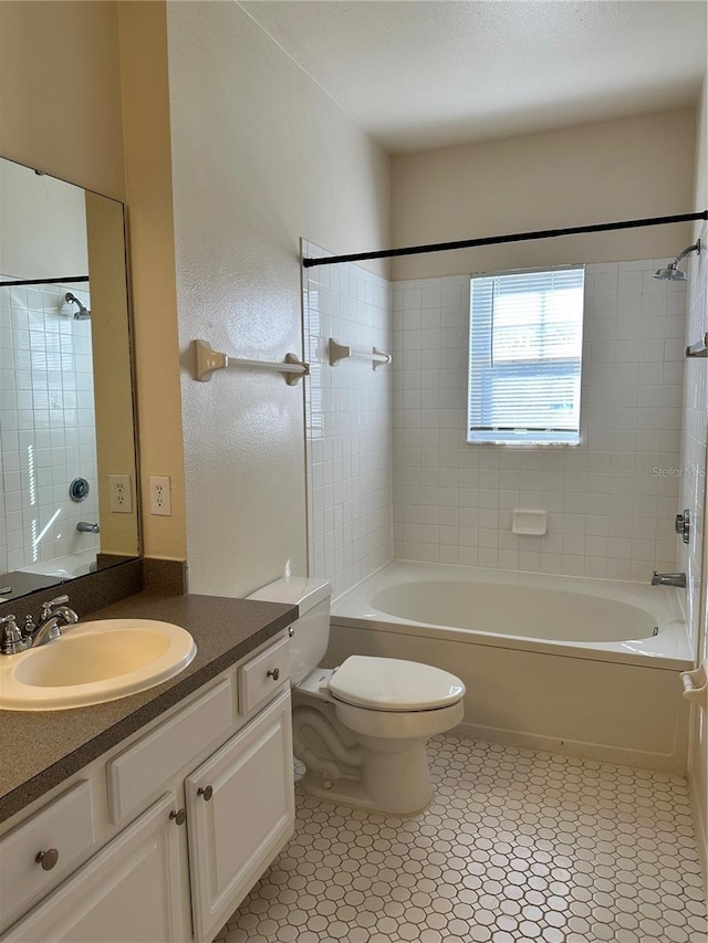 full bathroom featuring vanity, tiled shower / bath combo, and toilet