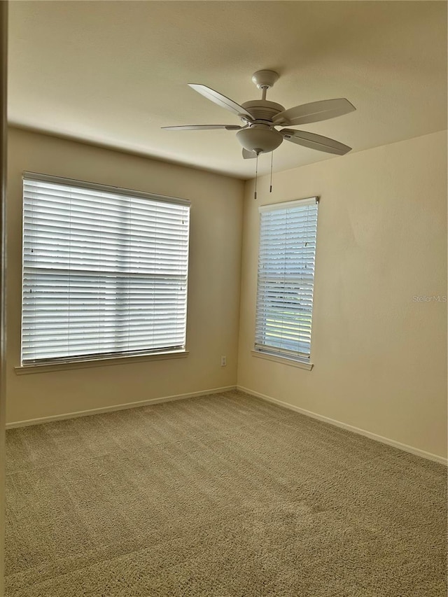 carpeted spare room with ceiling fan