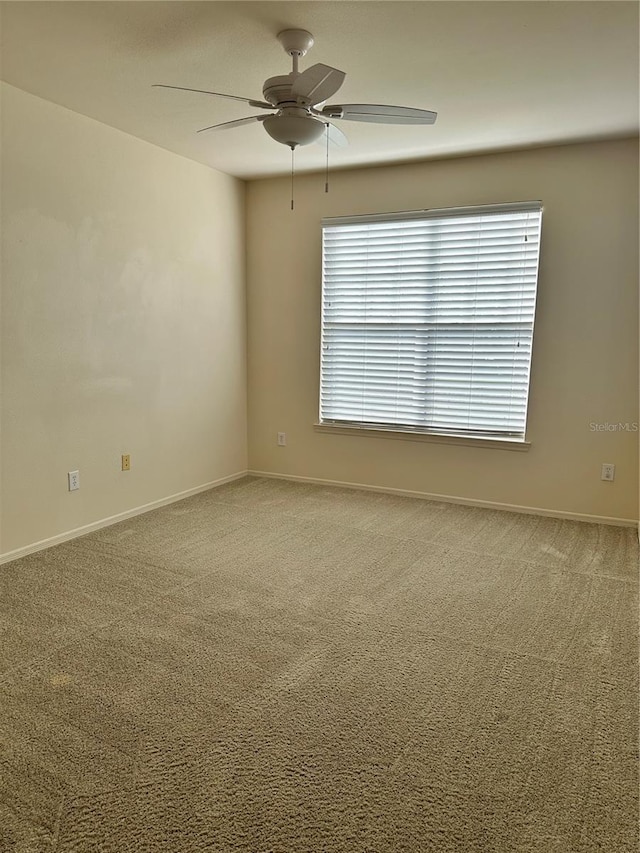 empty room featuring carpet, a wealth of natural light, and ceiling fan