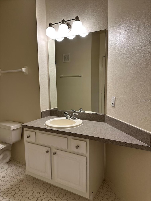 bathroom featuring tile patterned flooring, vanity, and toilet