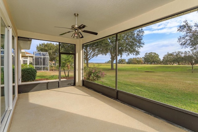 unfurnished sunroom with ceiling fan