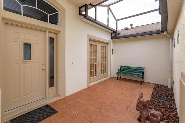 view of exterior entry featuring french doors and a patio