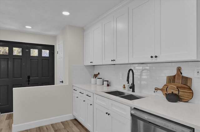 kitchen featuring stainless steel dishwasher, light hardwood / wood-style floors, white cabinets, and sink